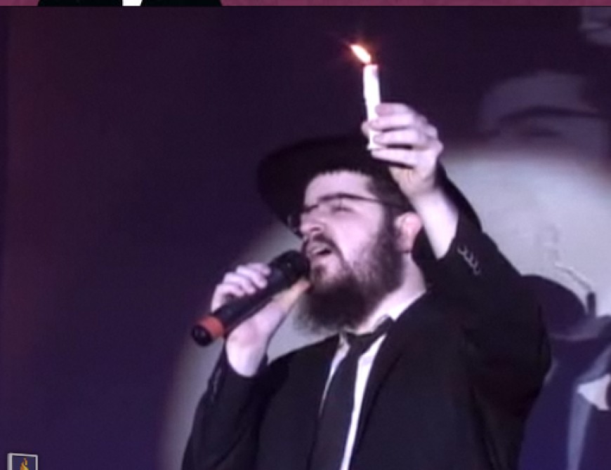 Benny Friedman holding a candle, singing don’t let the light go out